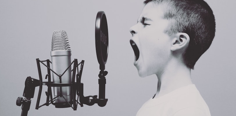 boy singing on microphone with pop filter