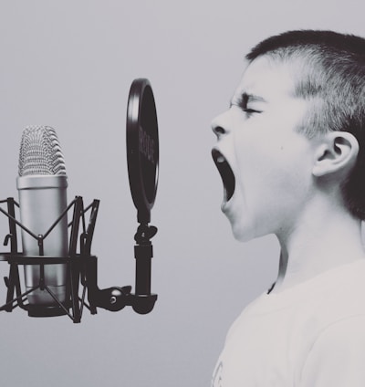 boy singing on microphone with pop filter