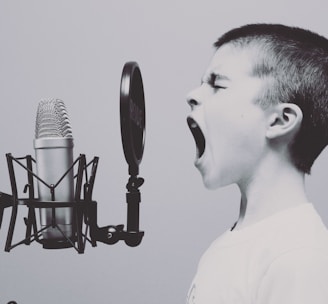 boy singing on microphone with pop filter