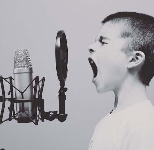 boy singing on microphone with pop filter