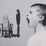 boy singing on microphone with pop filter