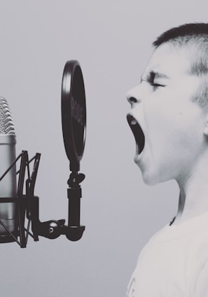 boy singing on microphone with pop filter