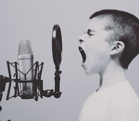 boy singing on microphone with pop filter