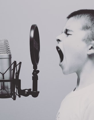 boy singing on microphone with pop filter