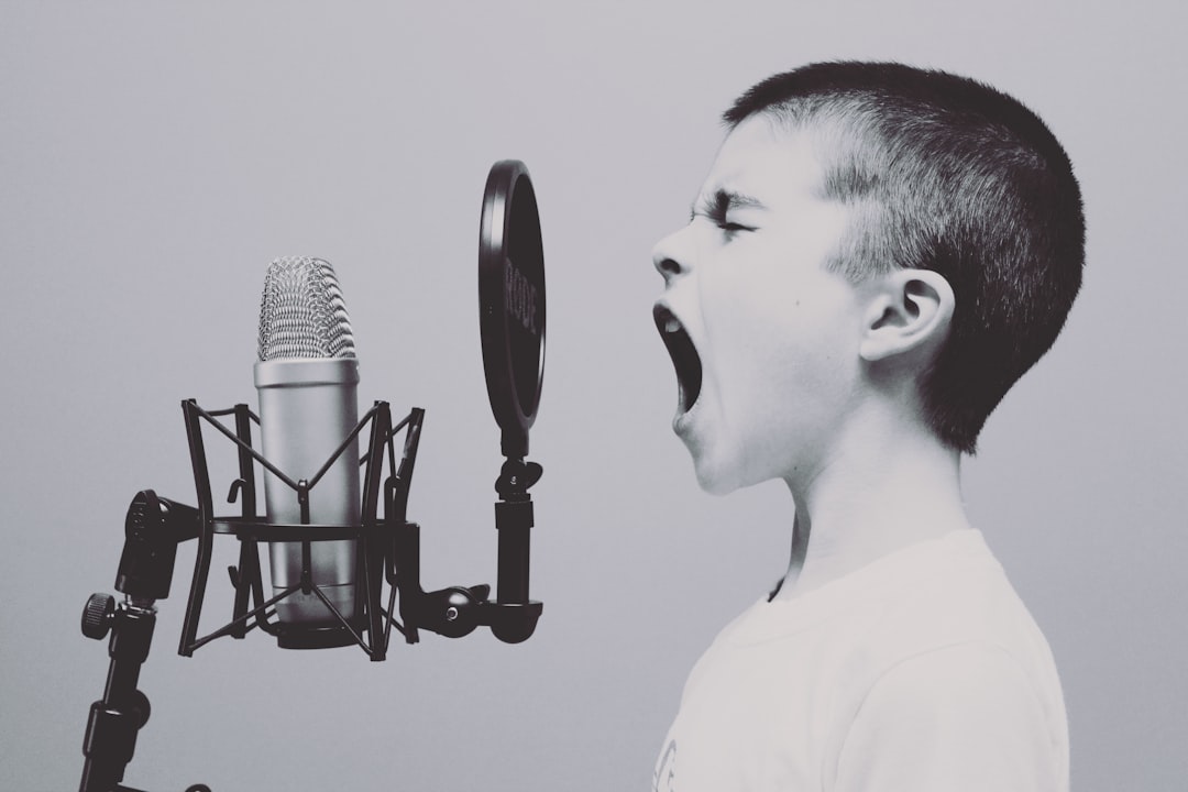 boy singing on microphone with pop filter,