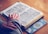 person reading a book with hands on top of book