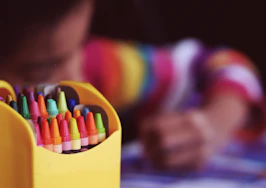 selective focal photo of crayons in yellow box