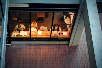 three persons sitting on chair beside table