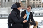 two men talking while sitting on bench