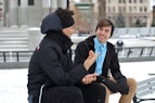 two men talking while sitting on bench