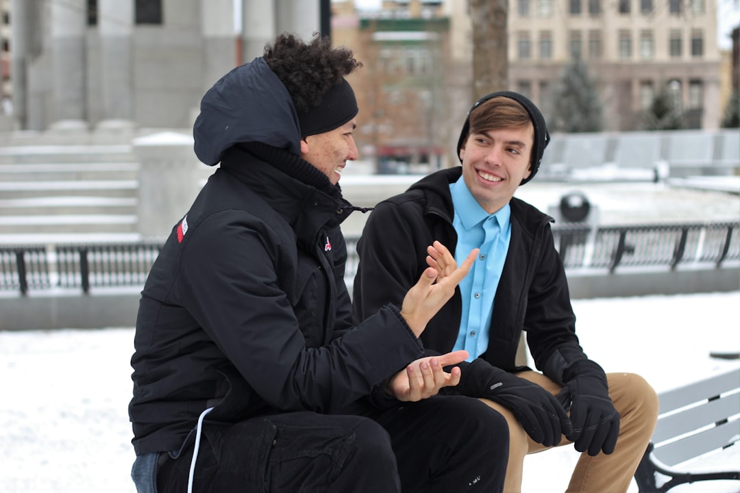 two men talking while sitting on bench, Men talking in the cold