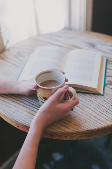 A cozy scene of a person wearing a ds story t-shirt, sitting peacefully with a cup of coffee in a sunlit room.