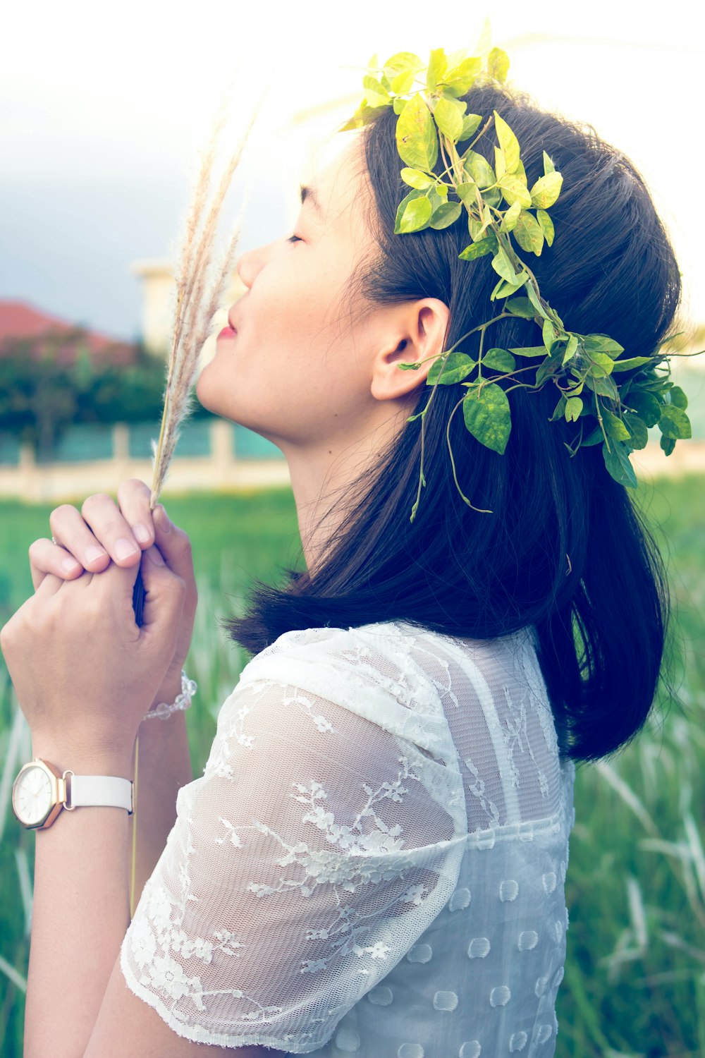 close photography of woman holding fern