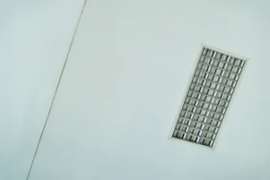 A sleek fluorescent ceiling fixture illuminating a minimalist kitchen.