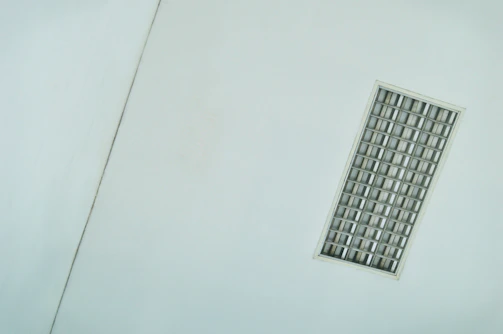 A sleek fluorescent ceiling fixture illuminating a minimalist kitchen.