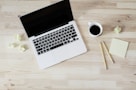 turned off MacBook Pro beside white ceramic mug filled with coffee
