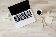 turned off MacBook Pro beside white ceramic mug filled with coffee