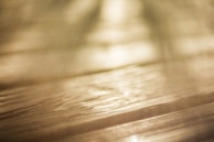 An artist painting on wood with soft, warm lighting.