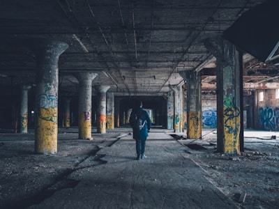 Group of urban explorers walking through an abandoned industrial building with flashlights.