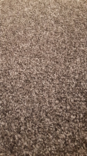 A close-up of a plush chenille rug in warm tones, highlighting its soft texture and dense weave.