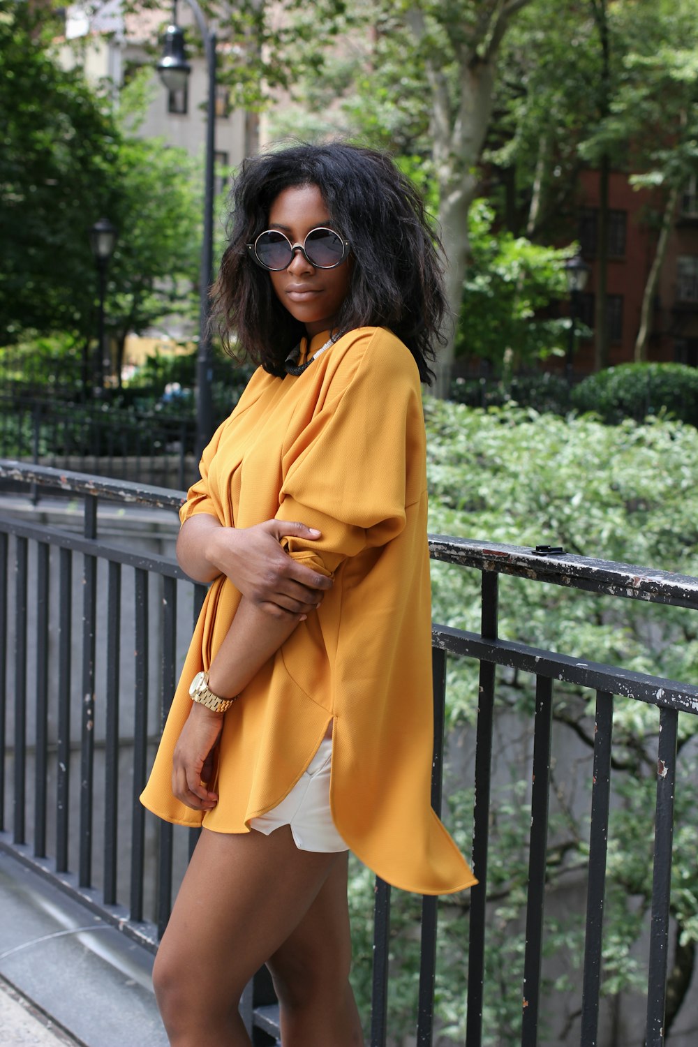 An African American girl standing in front of a fence.