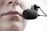 A close-up of a person's lips speaking into a black microphone headset, suggesting communication or recording.