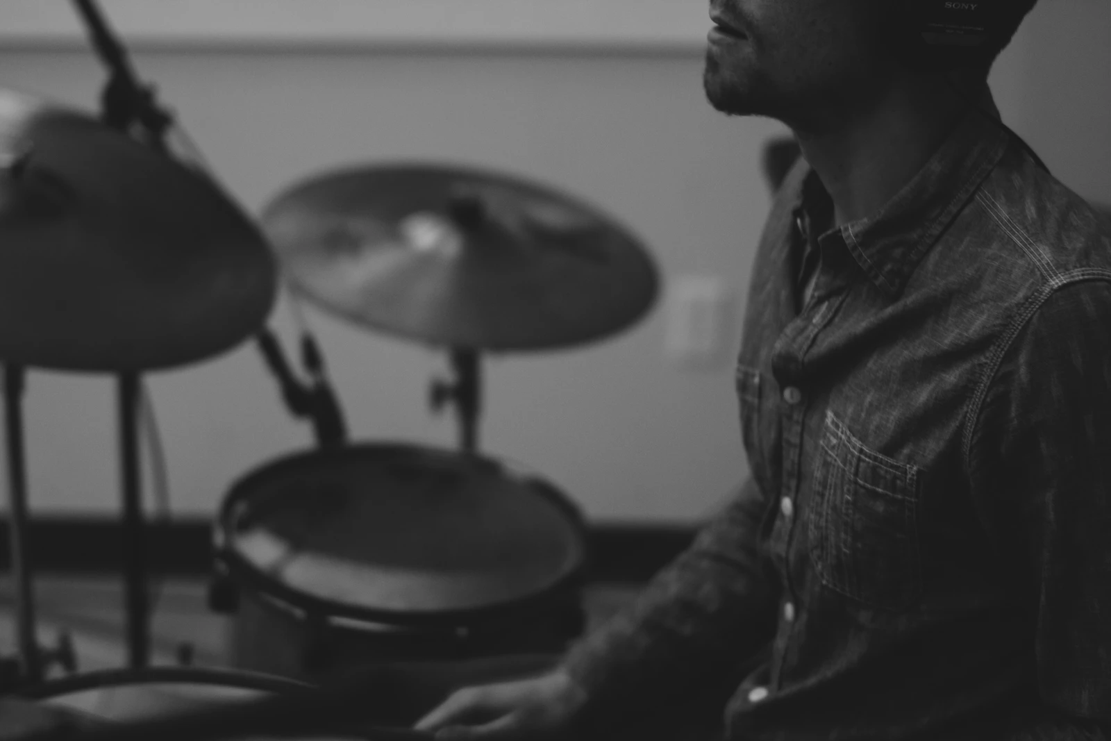 Grayscale photo of a man playing drums, focused and in the moment