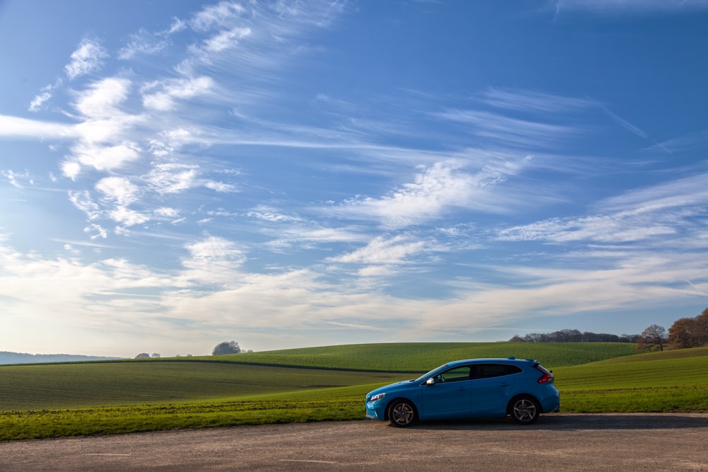 blue 5-door hatchback on asphalt road during daytime