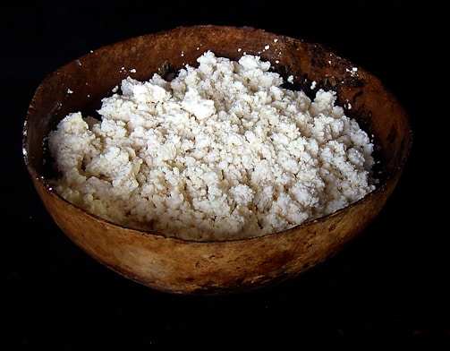 Freshly made cheese and yogurt displayed on a rustic wooden table.
