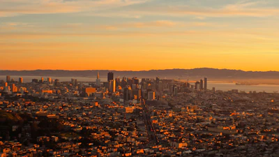 A sweeping aerial shot from the GTA 6 trailer, showing the sprawling city and coastline at sunset.