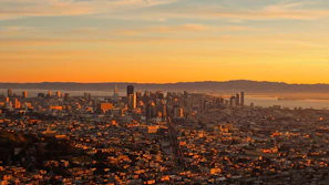 A vibrant cityscape from an open-world adventure game at sunset