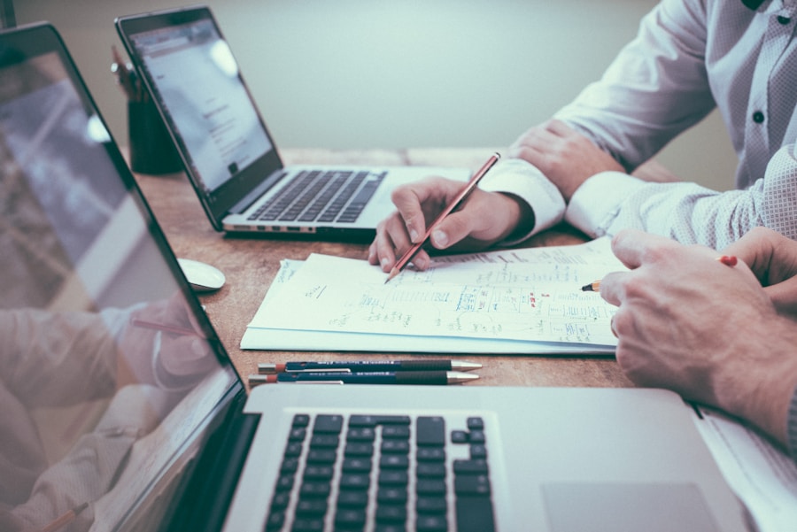 Person arbeitet an Unterlagen mit Diagrammen und Notizen