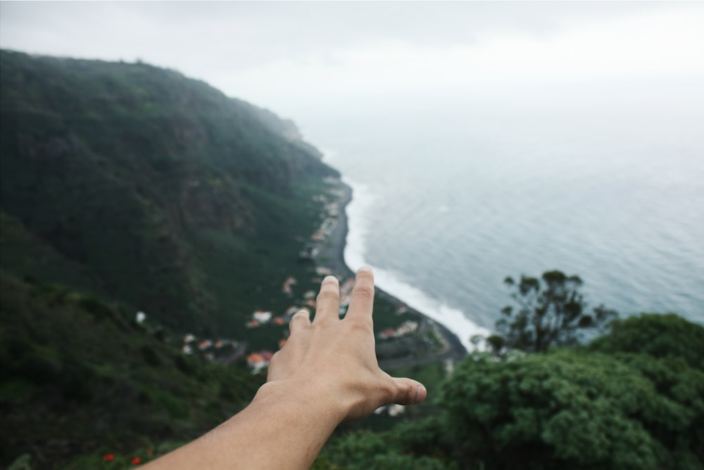 person trying to grab mountain