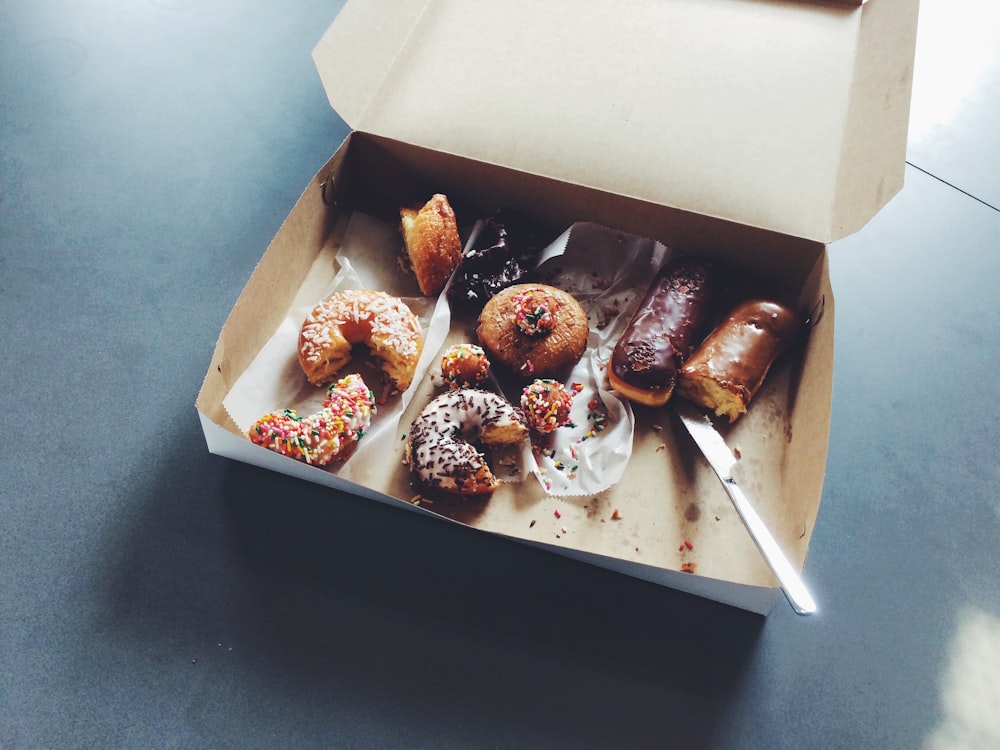 Box of half eaten donuts on an office break room table