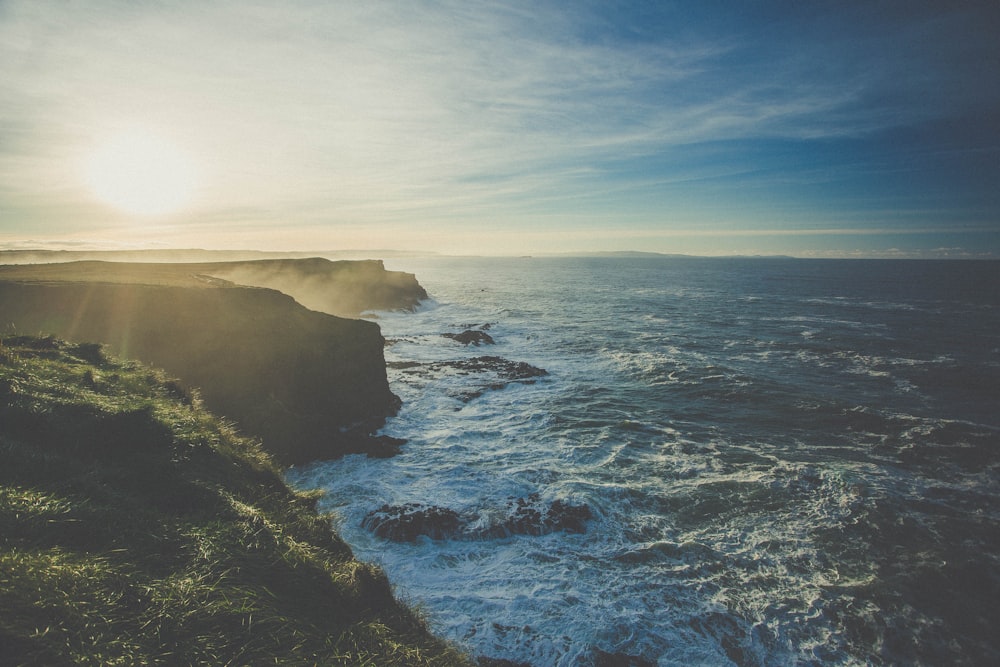 rock cliffs facing rippling body of water