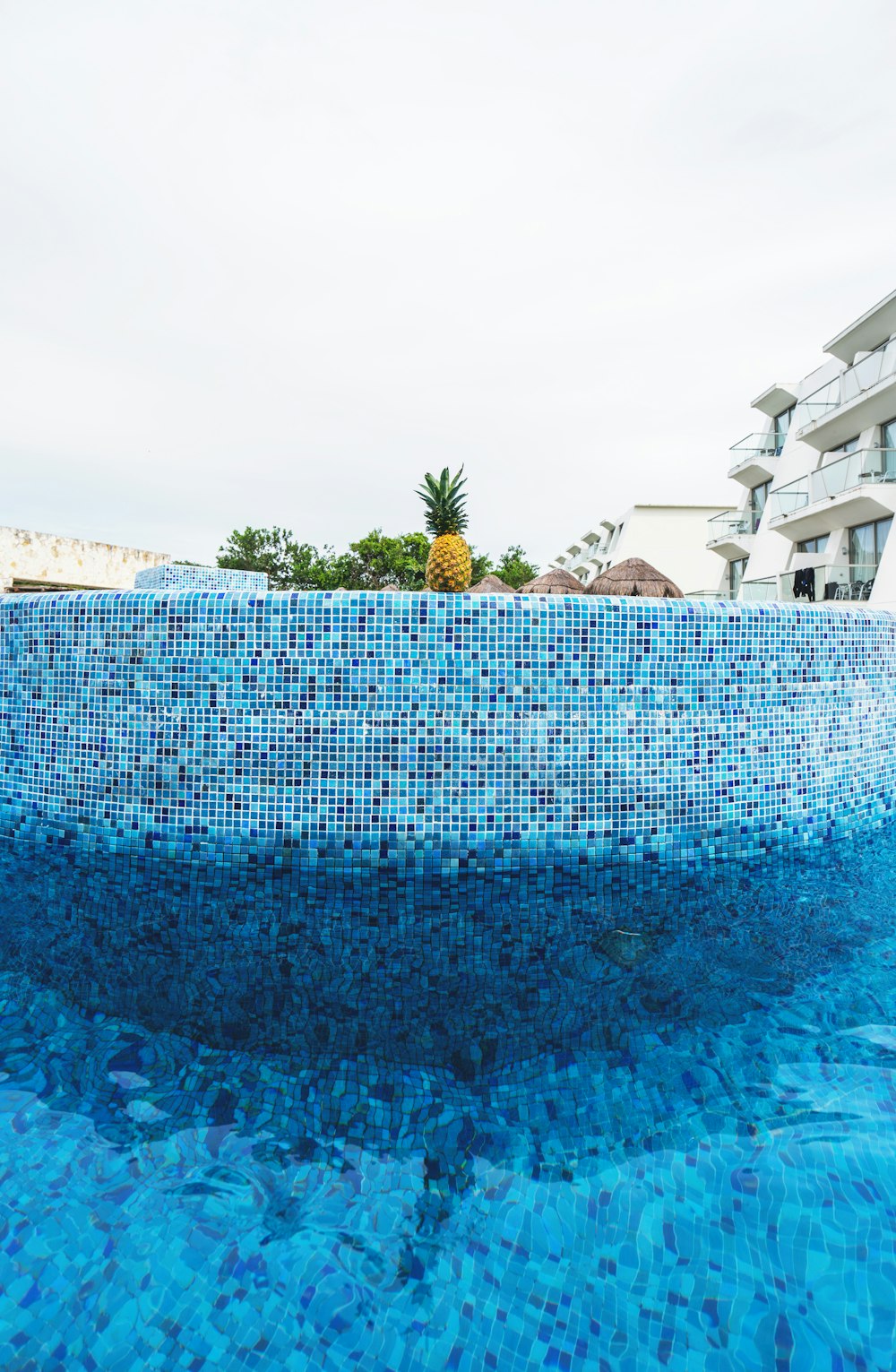 a blue swimming pool with a pineapple on top of it