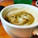 Close-up of a steaming cup of freshly brewed coffee on an office desk with a sleek automatic coffee machine in the background