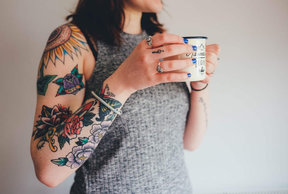 Mujer sosteniendo taza de cerámica blanca