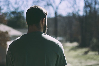 selective focus photography of man staring at woods