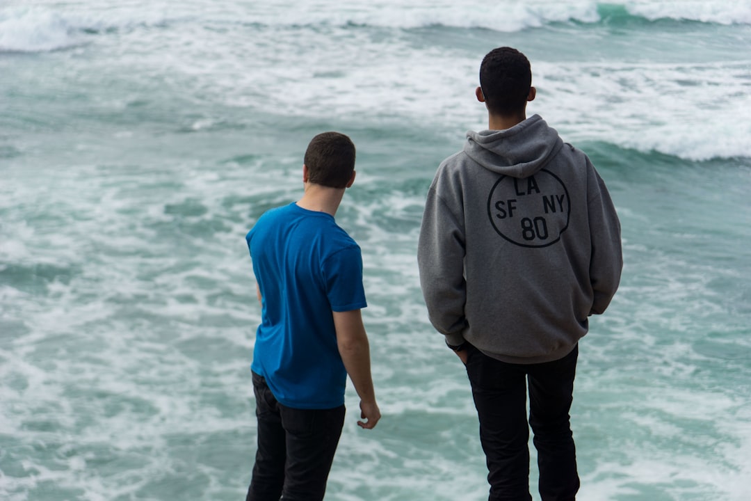 two men standing near body of water