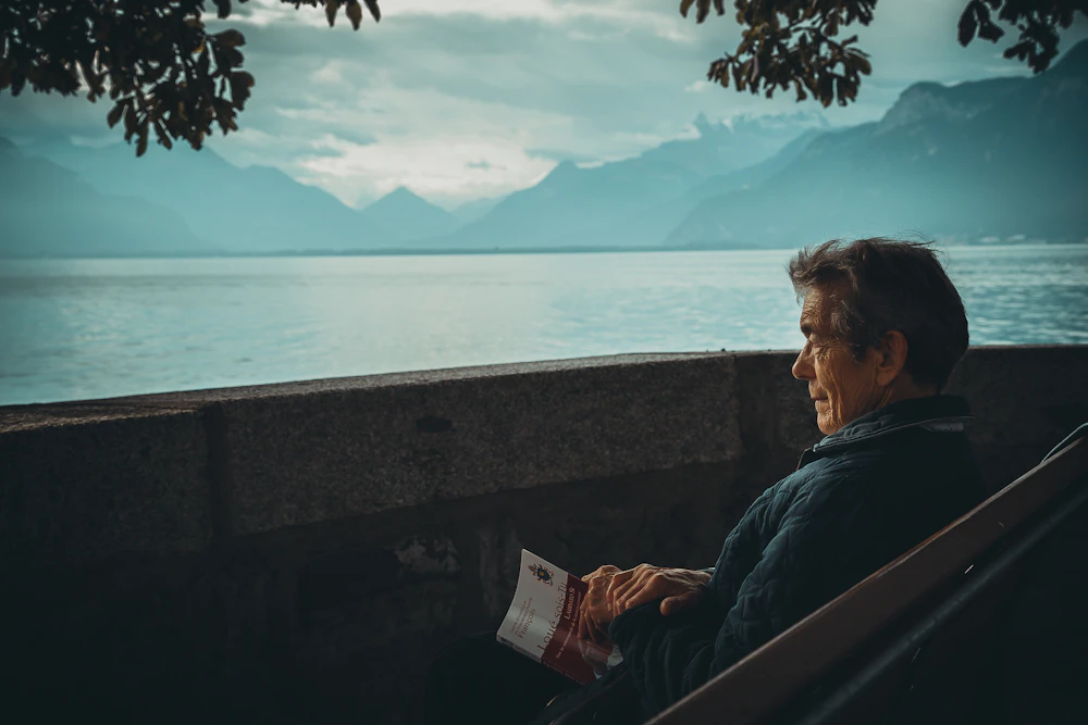 Older man relaxing and reading outdoors