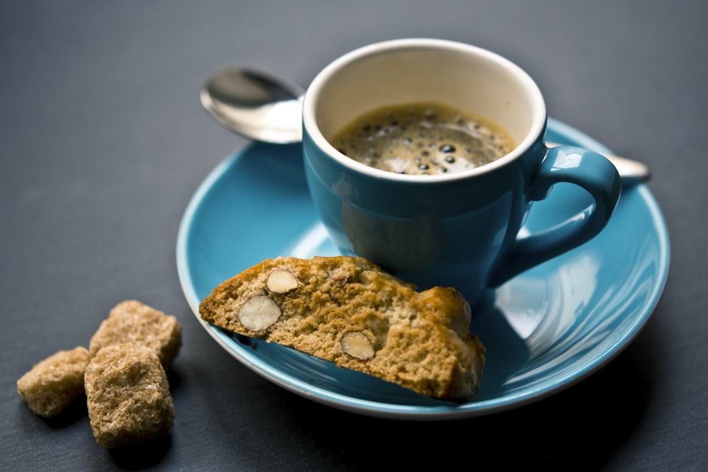 taza de café y pan en platillo fotografía de primer plano