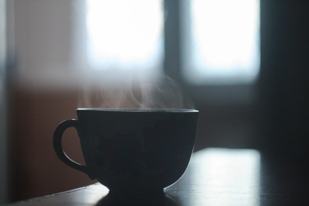 taza de té de cerámica negra sobre la mesa