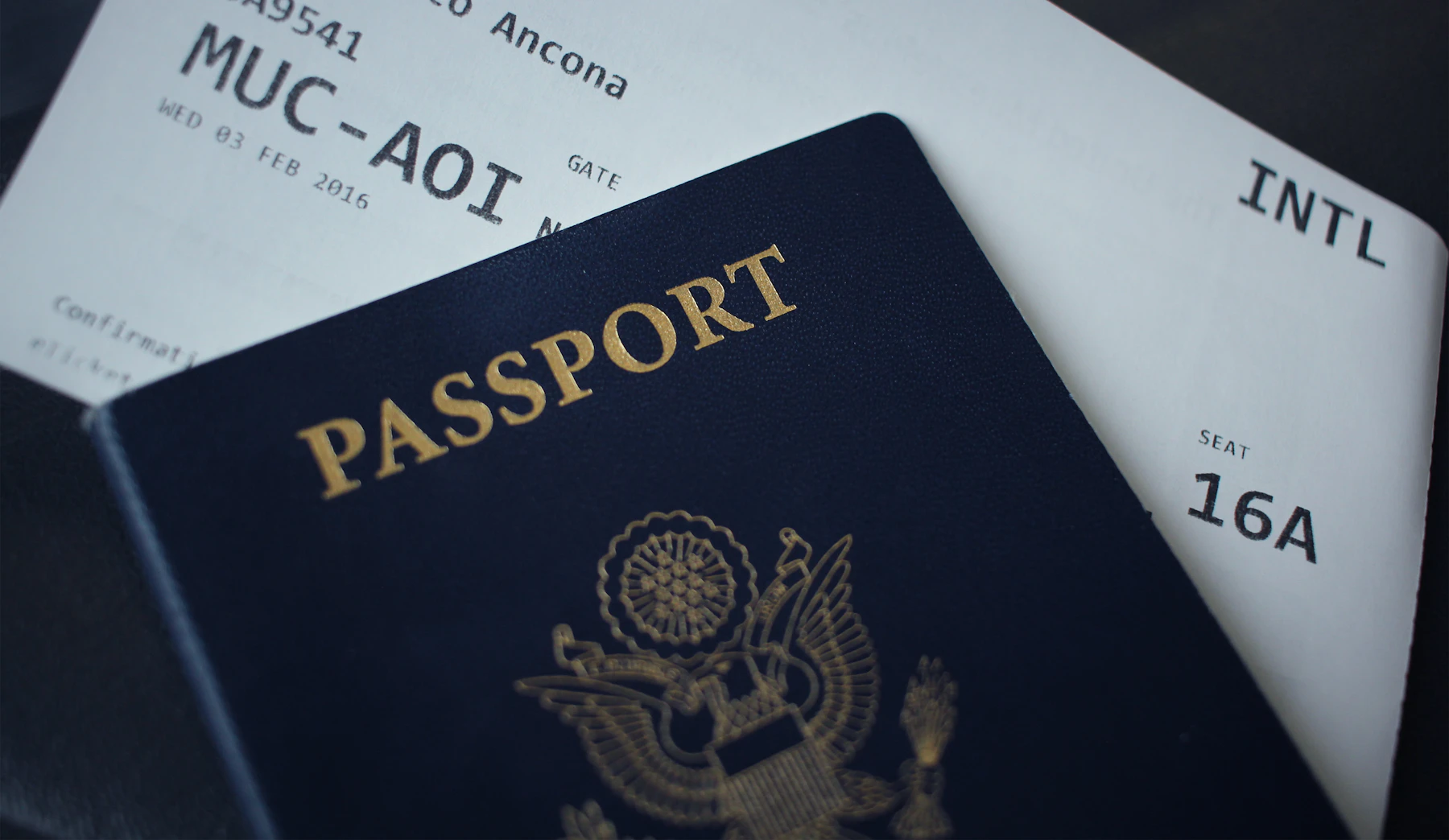 A passport resting on a boarding pass, representing international banking and travel