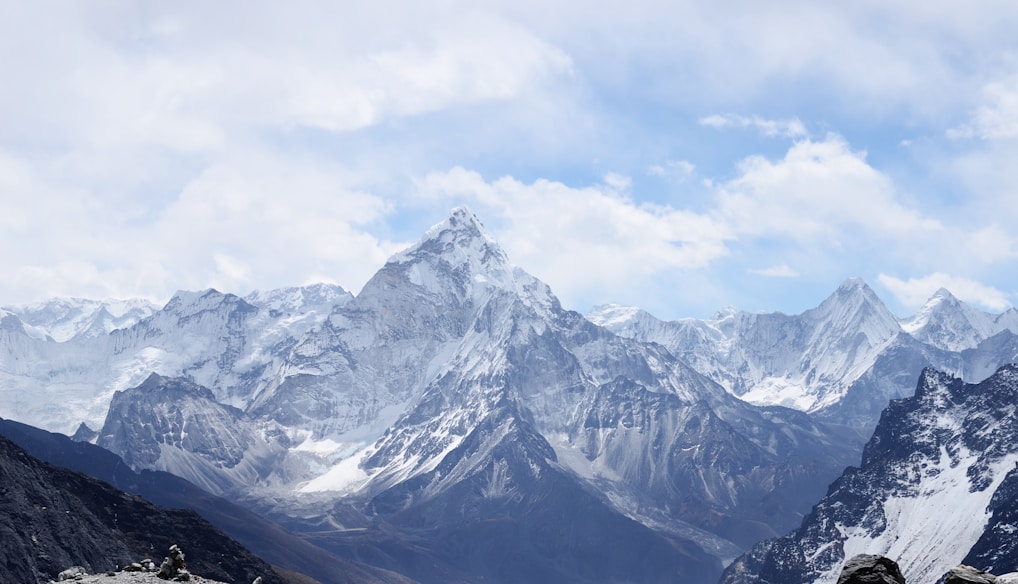 aerial photography of mountain range covered with snow under white and blue sky at daytime