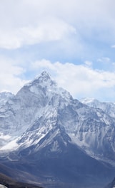 aerial photography of mountain range covered with snow under white and blue sky at daytime