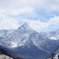 aerial photography of mountain range covered with snow under white and blue sky at daytime