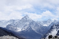 aerial photography of mountain range covered with snow under white and blue sky at daytime