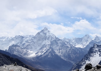 aerial photography of mountain range covered with snow under white and blue sky at daytime