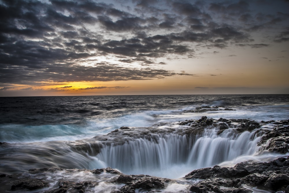 waterfalls under cloudy sky